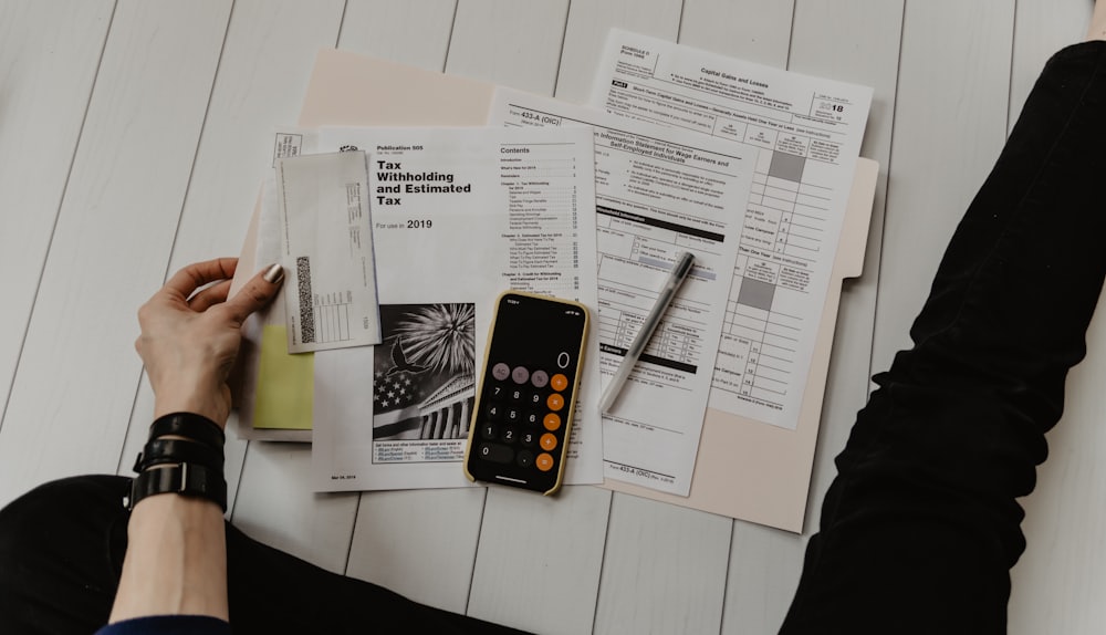 Documentos financeiros e calculadora sobre a mesa durante análise de contas